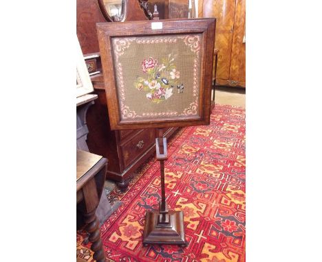 A Victorian oak framed floral tapestry pole screen on adjustable stand