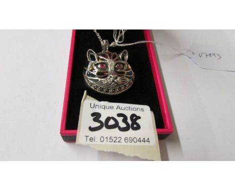 A silver and enamel Louis Wain style cat pendant necklace with ruby eyes.