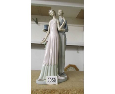 A Lladro figure group of a couple in evening dress.