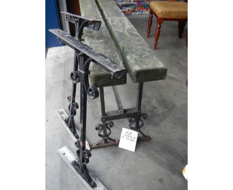 A scrolled metal bench and 2 bench ends.