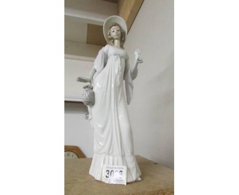 A tall Lladro figure of a lady.