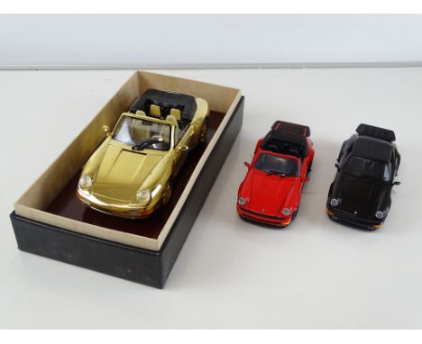 A pair of FRANKLIN MINT diecast 1:24 scale Porsche 911s together with a 1:18 scale GWILO Porsche 911 Carrera Cabrio 22ct gold