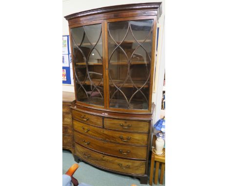 A mahogany two over three bow front chest on bracket feet, with an associated mahogany bow front glazed two door bookcase top