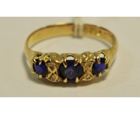An 18ct gold 'gypsy' ring set with three blue sapphires 2.6g gross