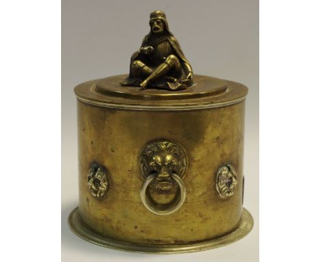 A brass tea caddy, lion mask handles, with four further lion masks, the lid surmounted with a model of a Bedouin elder