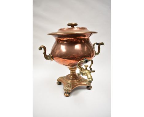 A Georgian copper and brass tea urn with S-scroll handles, scallop form quatreform base, 38cm tall