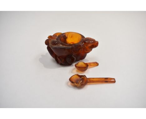 An early 20th Century Chinese carved amber salt, decorated depicting a bird amongst flowers, 3cm x 6cm, 23g