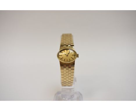 An 18ct gold cased Universal Genève ladies wristwatch, oval form gilt dial with baton markers.  The strap tests for 14k, 40g 