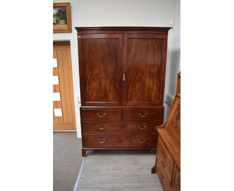 A circa 1790 mid George III flame mahogany linen press, the two doors (with key) opening to reveal all five linen trays on a 