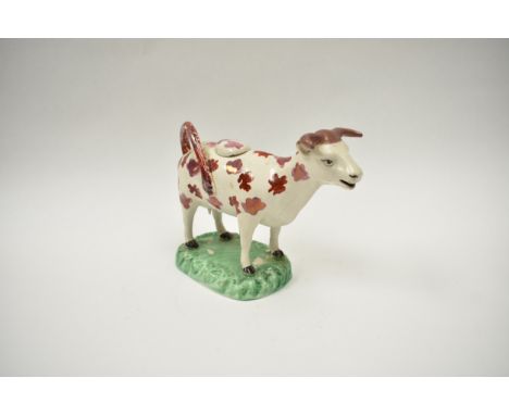 A 18th Century creamware cow creamer with lustre patch detail restoration and cracks present to legs and hoof. 14cm tall x 18