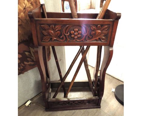 In the manner of 'Liberty &amp; Co' circa 1890, an Arts and Crafts carved walnut stick stand with tin liner drip tray, 76cm x