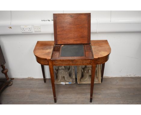 A George III mahogany breakfront desk/side table.  The central panel lifts to reveal a fitted writing surface and lidded comp