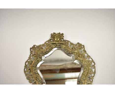 A vintage French lozenge-shaped bevelled mirror in gilt brass with ornate surround, 34.5cm x 24.5cm