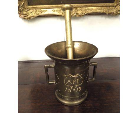 An early 17th Century North German bronze pestle and mortar, the twin handled mortar engraved APF 1618