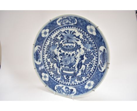A late 18th/early 19th Century Chinese unmarked blue and white charger with central image depicting large vase with figures, 