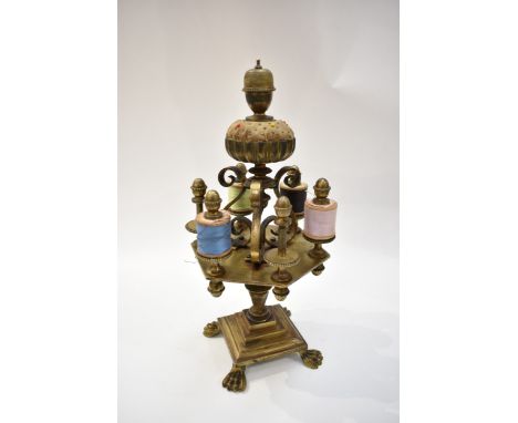 A heavy brass cotton reel holder with thimble in top