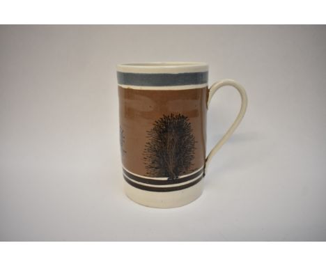 A 19th Century Mocha Ware mug, mushroom ground with black feathered trees, dark blue and black bands, 13.5cm tall