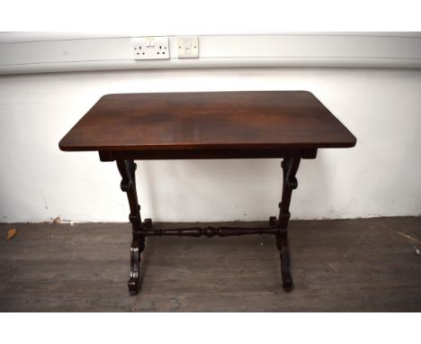 A circa 1830 Georgian walnut side table, the round cornered top over carved scroll supports and feet united by a carved and t