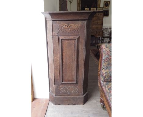 An 18th Century rustic oak floor standing corner cupboard with blacksmith made butterfly hinges, blind fretwork carved panels