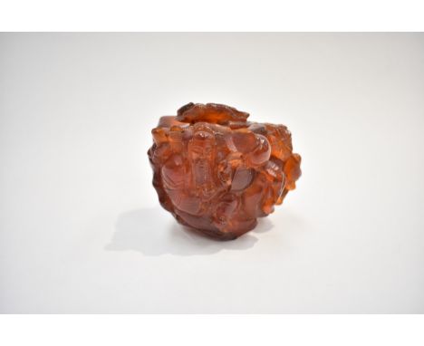 An early 20th Century Chinese root amber carved snuff bottle depicting figures surrounded by flowers/ foliage with carved dog