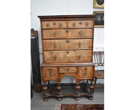 An 18th Century walnut chest on stand, the four long drawer top with crossbanded fronts, drop handles, D-moulding over a thre
