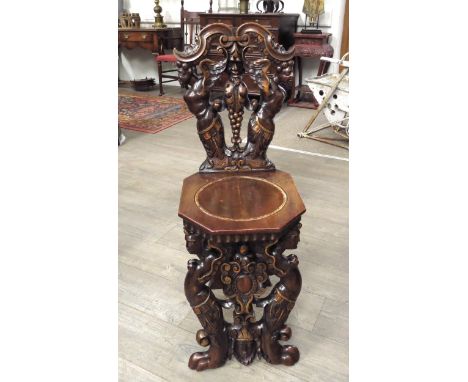 An Italian 18th Century carved walnut "Sgabello" chair with painted gilt relief, the winged males and grapevine backrest over