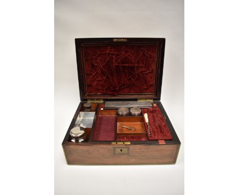 A Victorian walnut vanity box with brass edging and central plaque.  The top opens to reveal a velvet and silk lined interior