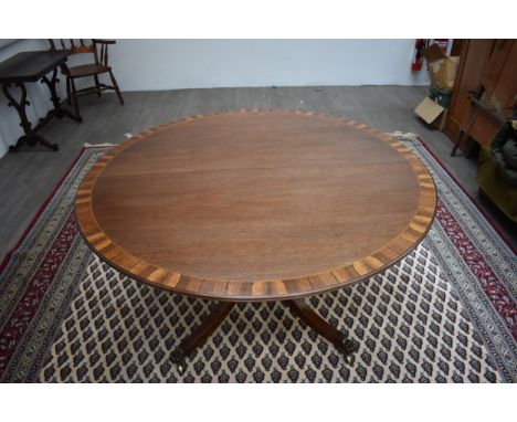In the manner of "William Tillman" a Regency revival mahogany circular top with rosewood crossbanding extending dining table 