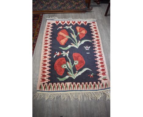 A flat weave rug decorated with large poppies, 172cm x 122cm