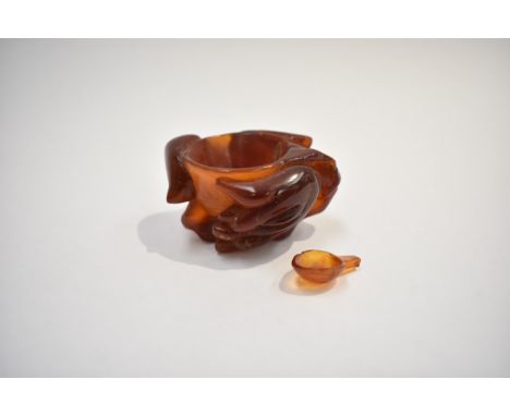 An early 20th Century Chinese carved amber salt decorated in foliage and Buddha's hand, 3cm x 6cm, 35g