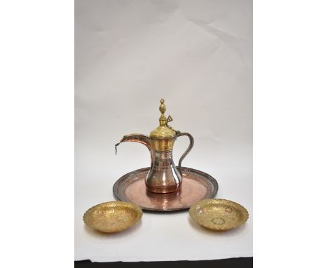 An Arabic brass and copper coffee pot, two decorative dishes and a tray