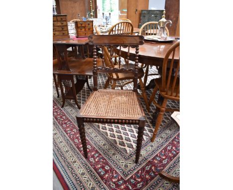 A William IV red walnut chair with carved and turned backrest over a caned seat on tapering bobbin-turned fore legs