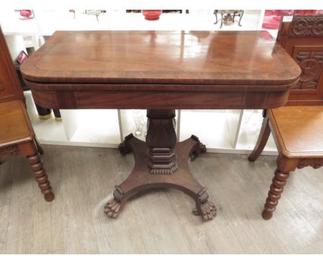 A Victorian mahogany tea table, the fold-over top over a plain frieze to a foliate carved column to quatreform base, lion paw