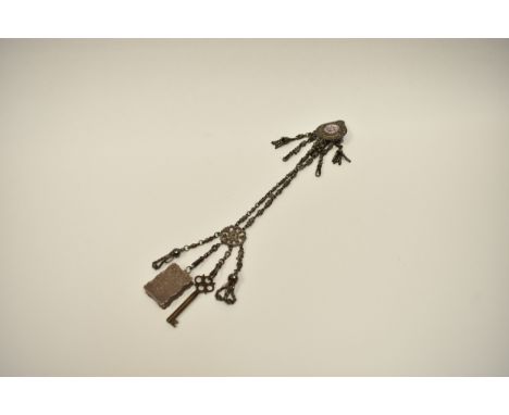 A Victorian metal chatelaine with marcasite decoration.  The belt clip is set with a hand-painted porcelain plaque depicting 