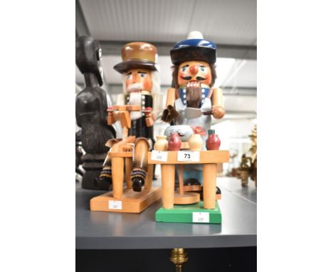 A vintage toymaker/potmaker nutcracker, h39cm, sold together with a similar stylenutcracker, (2)