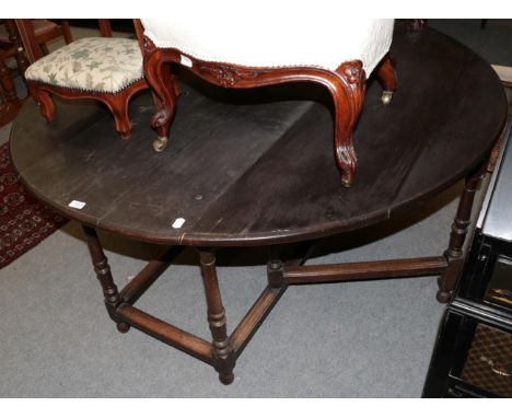 An oak gate leg dining table, 18th century in part, with turned legs and block feet 