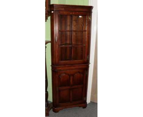 A Kumpers of Salisbury oak free-standing corner cabinet, modern, the upper section with a door enclosing fixed shelves, the b