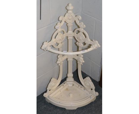 A painted cast metal corner stick stand with drip tray