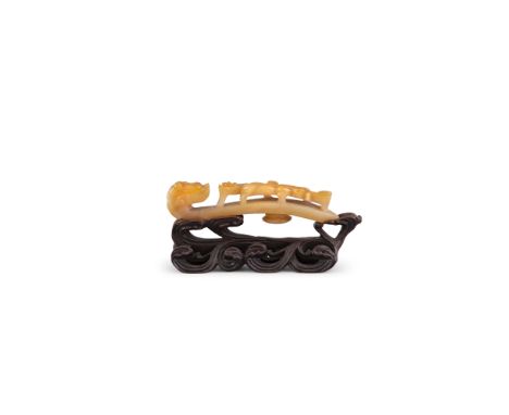 AN AMBER YELLOW AGATE BELTHOOK, 18TH/19TH Century, carved with a dragon’s head returning to face a qilong,  the underside set