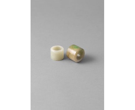 AN APPLE GREEN AND PALE JADE ARCHERS RING, Qing Dynasty (1644 - 1911/12); together with a Tibetan white jade ring (2)