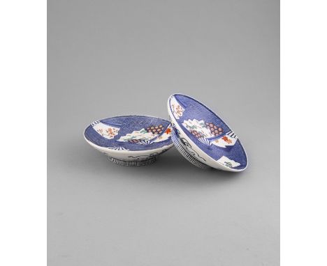 A PAIR OF NABESHIMA FOOTED DISHES, 19th century, of circular shape decorated in blue , iron red and green enamel, with scatte