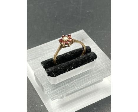 A 9ct gold ring with garnets and a central pearl.(1.4g)