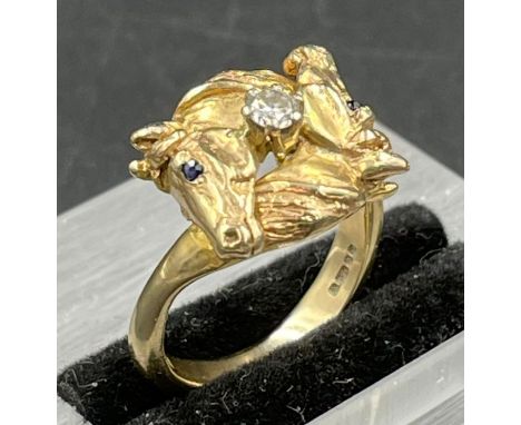 A 9ct gold ring, horse themed ring, a diamond set between two horse heads. Size K1/2 and approximate weight 5.5g.