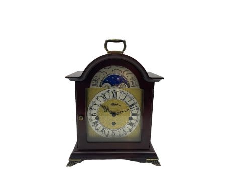 Compact late 20th century German Westminster chiming mantle clock in a break arch mahogany effect case with a brass carrying 