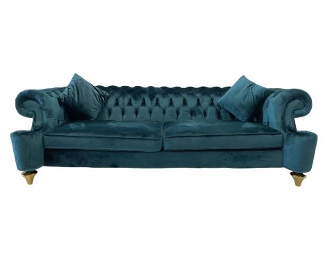 Chesterfield style three seat sofa, scrolled arms and uprights, upholstered in buttoned teal velvet, on turned tapering brass