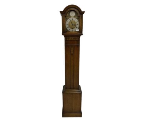 Mid-20th century “Grandmother” clock in a light oak case with a break arch top and conforming glazed hood door, with a stylis