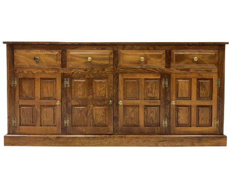 Elm sideboard, fitted with four drawers over four cupboard doors, opening to reveal one fixed shelf, raised on a plinth base 