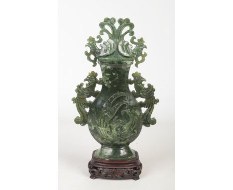 An early 20th century Chinese spinach jade coloured baluster urn and cover on hardwood plinth. With flat scrolling handles fo