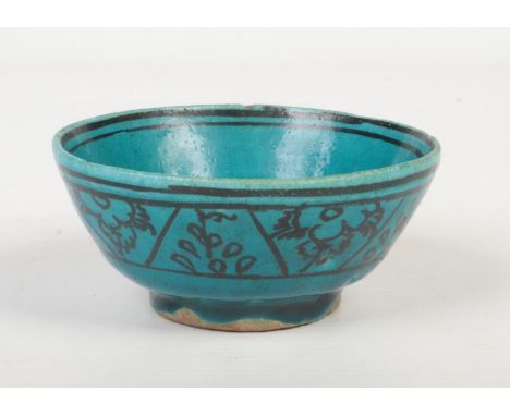 A 19th century Persian turquoise glazed earthenware bowl. With black enamel bands of stylized flowers. Label to the underside