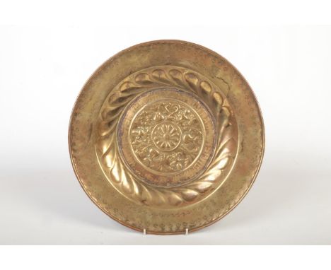 A 17th century brass alms dish. Embossed with a rosette centre under a gadrooned well and with a punch decorated border under